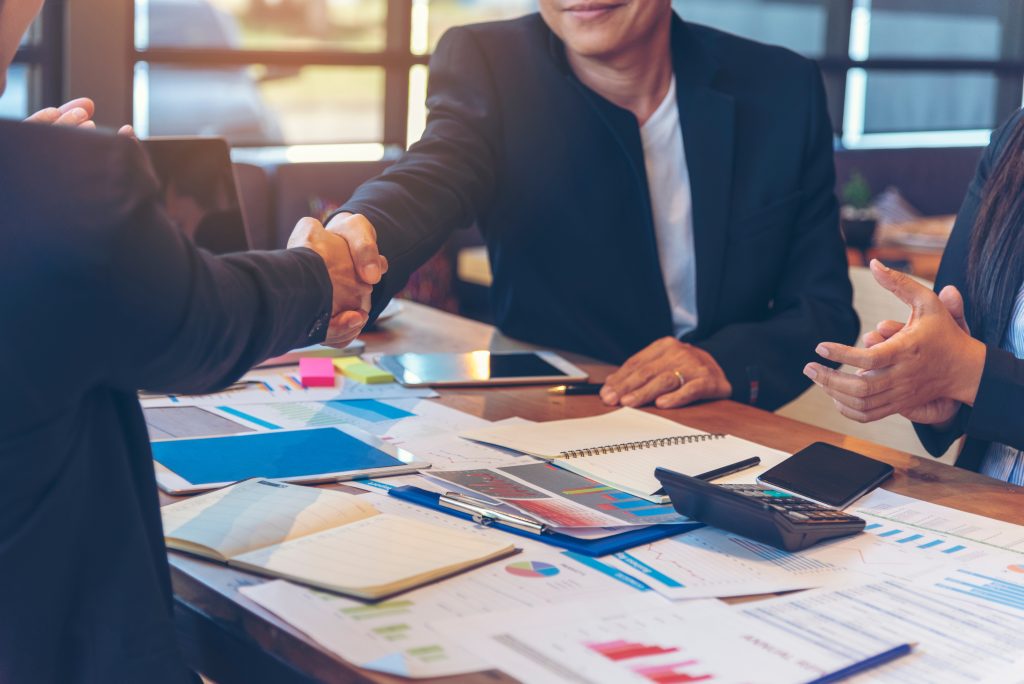 Team Business Partners shaking hands together to Greeting Start up small business in meeting room. Shakehand teamwork partners at modern office handshake together. Business mergers and acquisitions